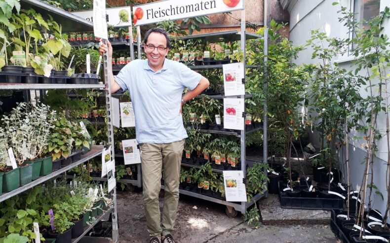 Interview mit Markus Amann vor Regalen mit Jungpflanzen