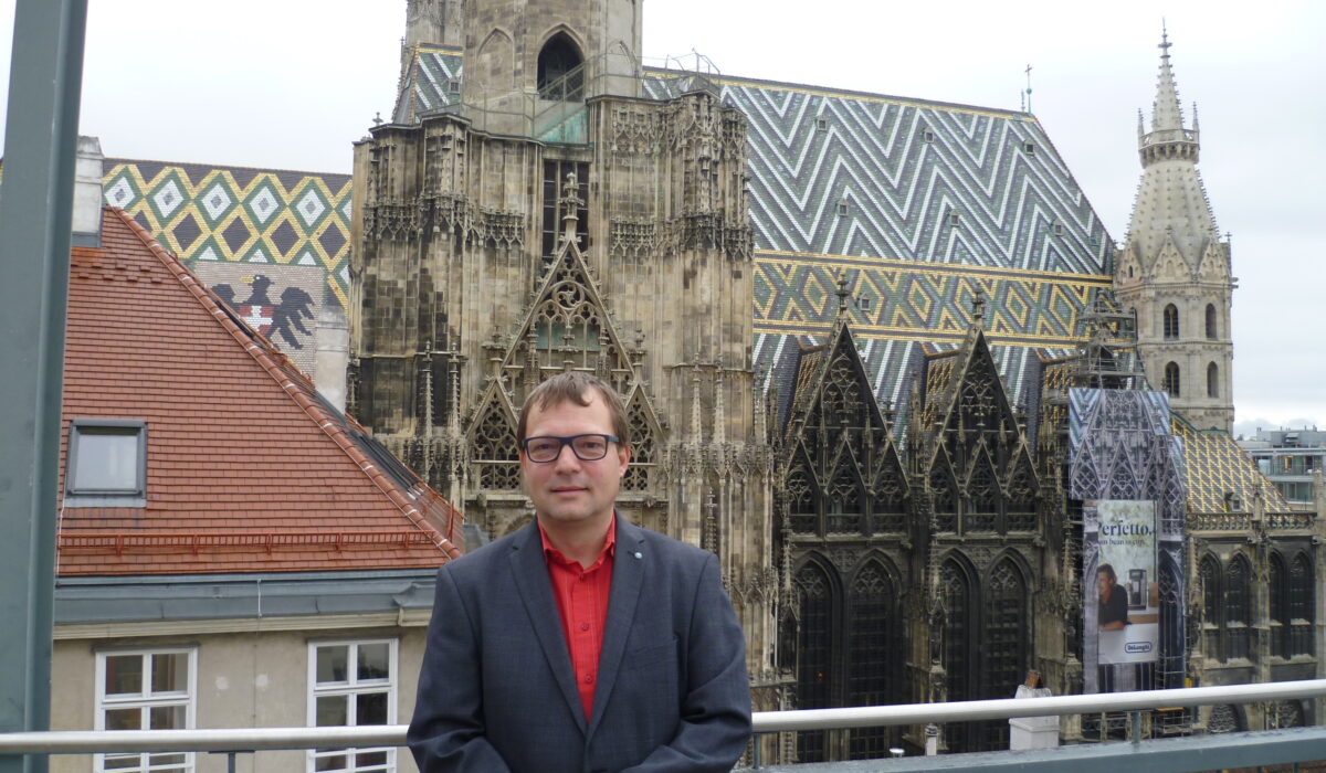Markus Gerhartinger auf Terrasse mit Stephansdom im Hintergrund