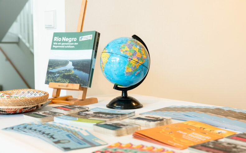 Infostand-Tisch mit Broschüren und Infomaterial und einem Globus.