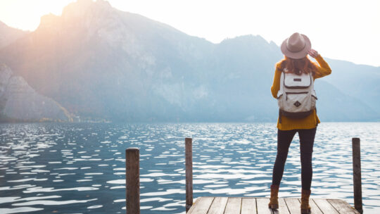 Mädchen steht an einem Steg am Traunsee mit Blick auf die Alpen